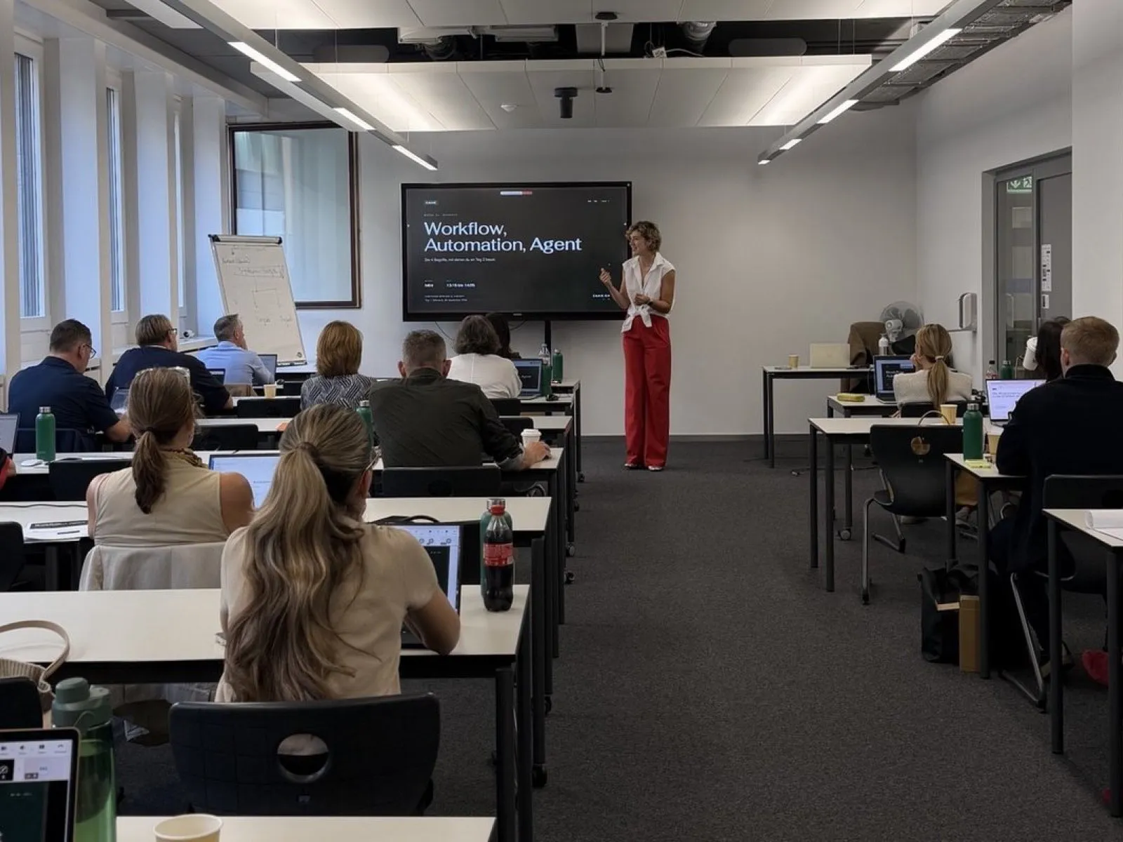 A tutor teaching the whole group in the course room in Zurich